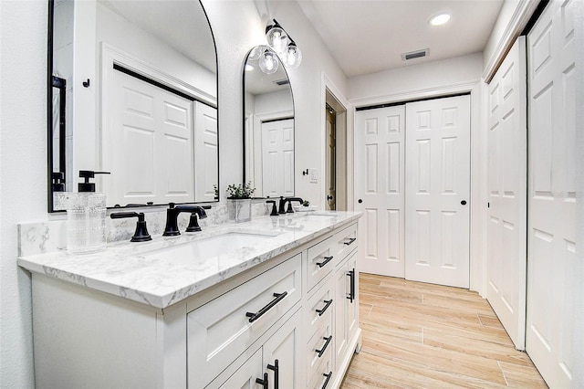 10900 65th Way N, Pinellas Park, FL 33782 - bathroom with a closet, double vanity, wood finished floors, and recessed lighting