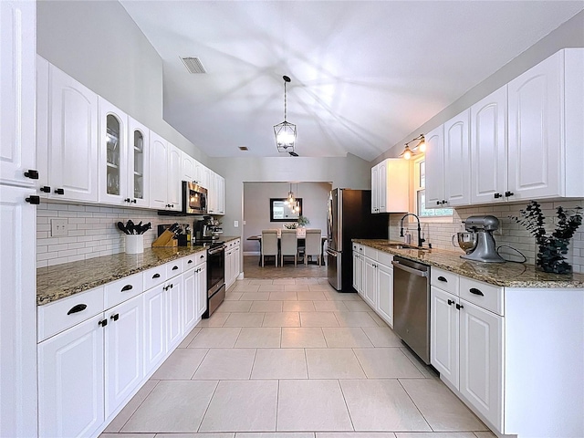 1437 Stonehenge Way, Palm Harbor, FL 34683 - kitchen featuring appliances with stainless steel finishes, tasteful backsplash, dark stone counters, glass insert cabinets, and white cabinets