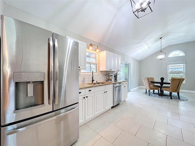 1437 Stonehenge Way, Palm Harbor, FL 34683 - kitchen featuring appliances with stainless steel finishes, lofted ceiling, light stone counters, decorative backsplash, and white cabinets