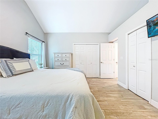 1437 Stonehenge Way, Palm Harbor, FL 34683 - bedroom featuring multiple closets, light wood-style flooring, and lofted ceiling