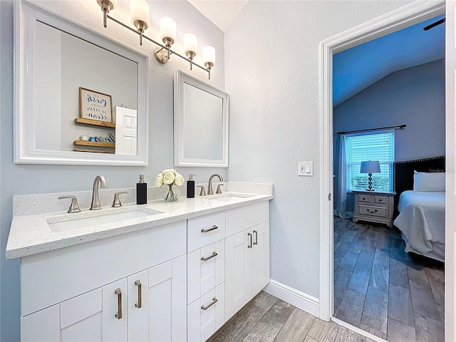 1437 Stonehenge Way, Palm Harbor, FL 34683 - bathroom with vaulted ceiling, double vanity, ensuite bathroom, wood finished floors, and a textured wall