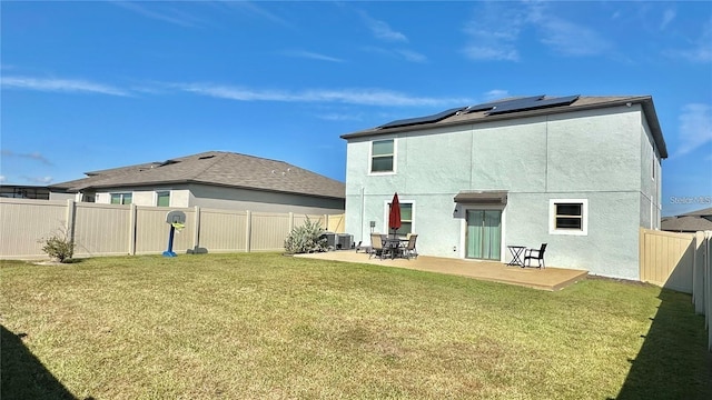 31363 Sun Kettle Loop, Wesley Chapel, FL 33545 - rear view of property featuring a patio area, solar panels, stucco siding, and a fenced backyard