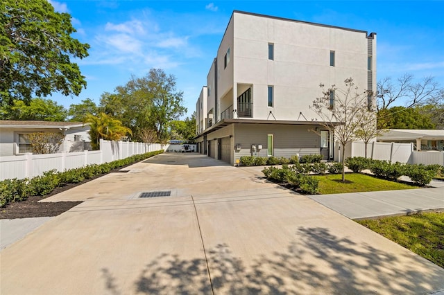 4311 W Fig St Unit 1, Tampa, FL 33609 - view of side of property with an attached garage, concrete driveway, and a balcony