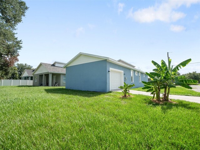 239 Burbank Ave, Lakeland, FL 33801 - view of side of home with a garage, stucco siding, and concrete driveway