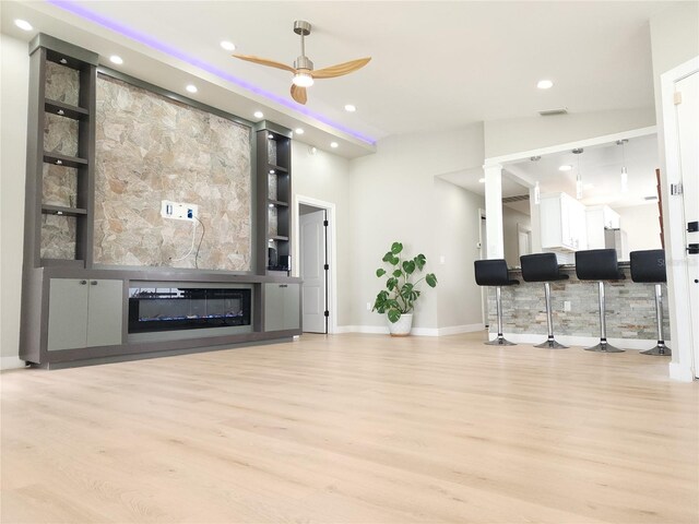11653 Orleans Ln, Port Richey, FL 34668 - living area featuring light wood-style floors, a ceiling fan, a glass covered fireplace, and recessed lighting