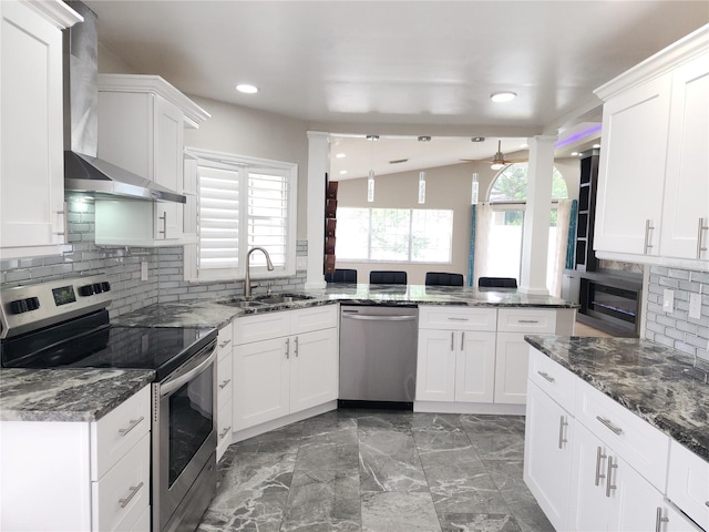 11653 Orleans Ln, Port Richey, FL 34668 - kitchen featuring stainless steel appliances, wall chimney range hood, a peninsula, tasteful backsplash, and recessed lighting