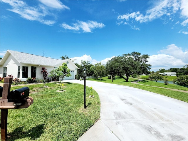11653 Orleans Ln, Port Richey, FL 34668 - view of front of property featuring driveway, a front lawn, an attached garage, and stucco siding