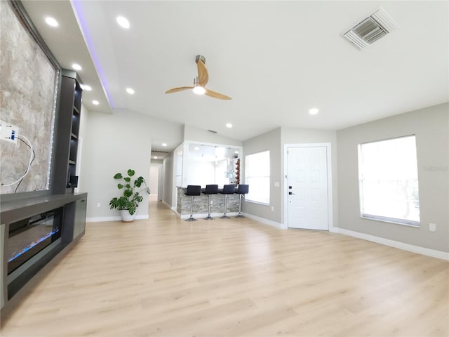 11653 Orleans Ln, Port Richey, FL 34668 - living area with light wood-type flooring, a ceiling fan, recessed lighting, vaulted ceiling, and a glass covered fireplace
