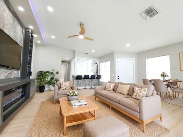 11653 Orleans Ln, Port Richey, FL 34668 - living room with light wood-type flooring, recessed lighting, a ceiling fan, a glass covered fireplace, and lofted ceiling