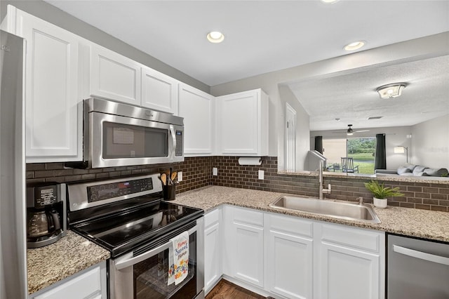 6919 Hawthorne Trace Ln, Riverview, FL 33578 - kitchen with appliances with stainless steel finishes, white cabinetry, decorative backsplash, light stone countertops, and recessed lighting