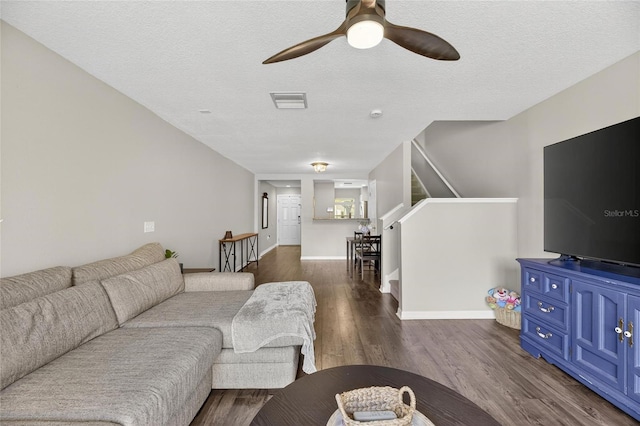 6919 Hawthorne Trace Ln, Riverview, FL 33578 - living area featuring a ceiling fan, dark wood-type flooring, a textured ceiling, and stairs