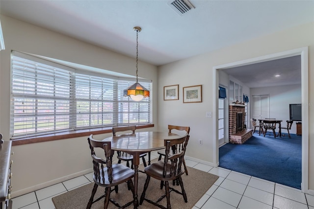 1302 Ivywood Dr, Brandon, FL 33510 - dining space featuring a fireplace, light tile patterned floors, and light colored carpet