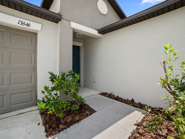 13646 Wild Ginger St, Riverview, FL 33579 - doorway to property featuring stucco siding and an attached garage