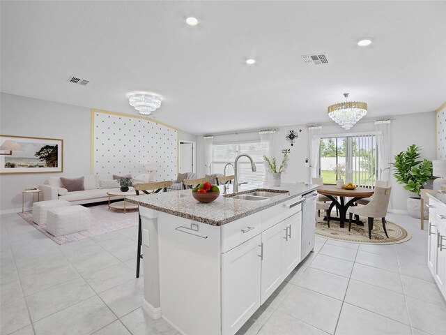 13646 Wild Ginger St, Riverview, FL 33579 - kitchen with a chandelier, stainless steel dishwasher, light stone countertops, white cabinetry, and an island with sink