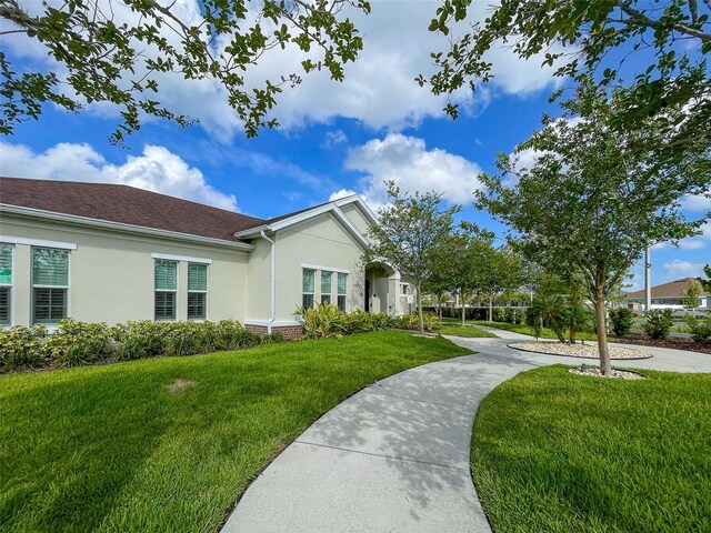 13646 Wild Ginger St, Riverview, FL 33579 - view of side of home with stucco siding and a yard