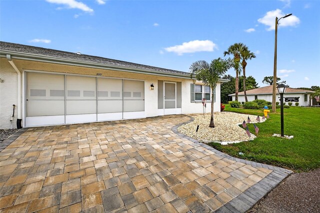 2201 Hartlebury Way Unit 2201, Sun City Center, FL 33573 - ranch-style home with a front lawn, decorative driveway, stucco siding, and a garage