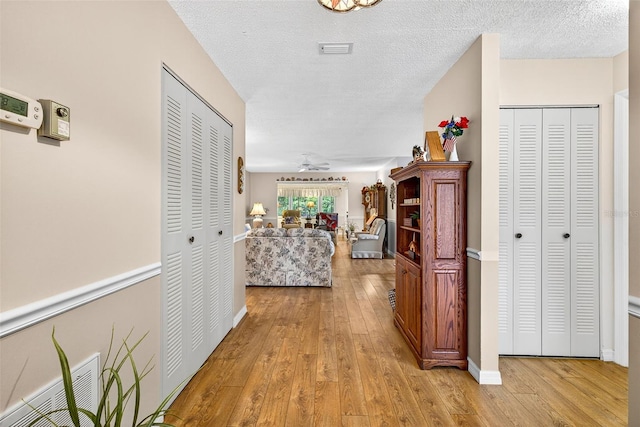 2201 Hartlebury Way Unit 2201, Sun City Center, FL 33573 - corridor with light wood finished floors and a textured ceiling