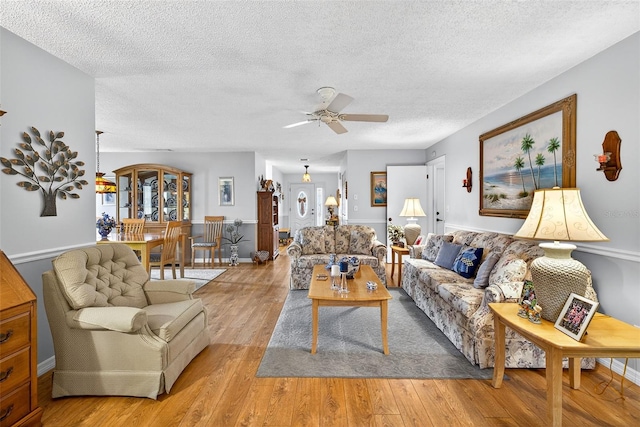 2201 Hartlebury Way Unit 2201, Sun City Center, FL 33573 - living room featuring a ceiling fan, a textured ceiling, and light wood-style floors
