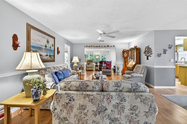 2201 Hartlebury Way Unit 2201, Sun City Center, FL 33573 - living room featuring a textured ceiling, ceiling fan, and light wood-style floors