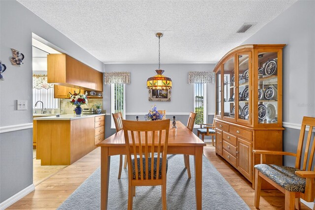 2201 Hartlebury Way Unit 2201, Sun City Center, FL 33573 - dining area featuring healthy amount of natural light, light wood-type flooring, and a textured ceiling