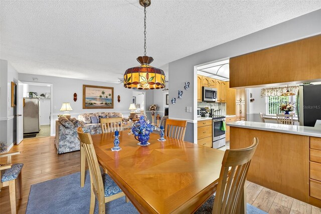 2201 Hartlebury Way Unit 2201, Sun City Center, FL 33573 - dining area with light wood-type flooring and a textured ceiling