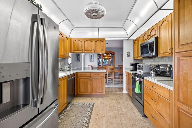 2201 Hartlebury Way Unit 2201, Sun City Center, FL 33573 - kitchen featuring appliances with stainless steel finishes, light wood finished floors, light countertops, and brown cabinetry