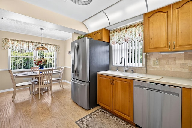 2201 Hartlebury Way Unit 2201, Sun City Center, FL 33573 - kitchen with appliances with stainless steel finishes, light countertops, light wood-style flooring, backsplash, and brown cabinets