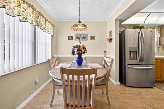 2201 Hartlebury Way Unit 2201, Sun City Center, FL 33573 - dining area with a textured ceiling, light wood finished floors, and crown molding