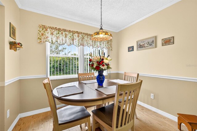 2201 Hartlebury Way Unit 2201, Sun City Center, FL 33573 - dining room with a textured ceiling, light wood-style floors, and ornamental molding