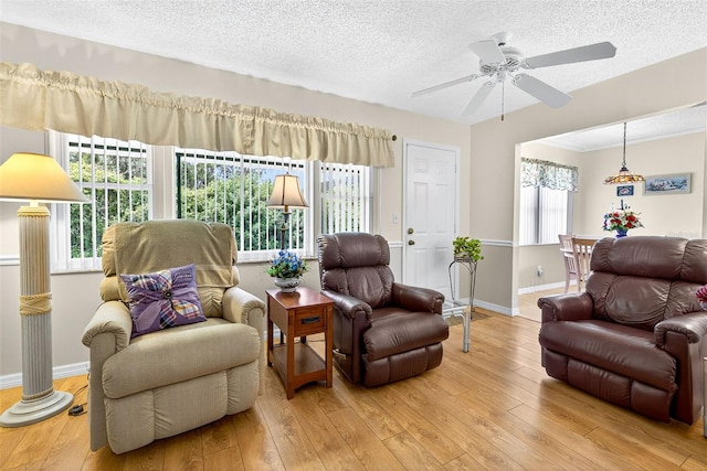 2201 Hartlebury Way Unit 2201, Sun City Center, FL 33573 - living room featuring a textured ceiling, wood-type flooring, and a ceiling fan