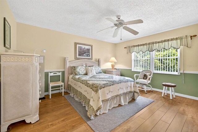 2201 Hartlebury Way Unit 2201, Sun City Center, FL 33573 - bedroom with hardwood / wood-style flooring, a textured ceiling, and a ceiling fan
