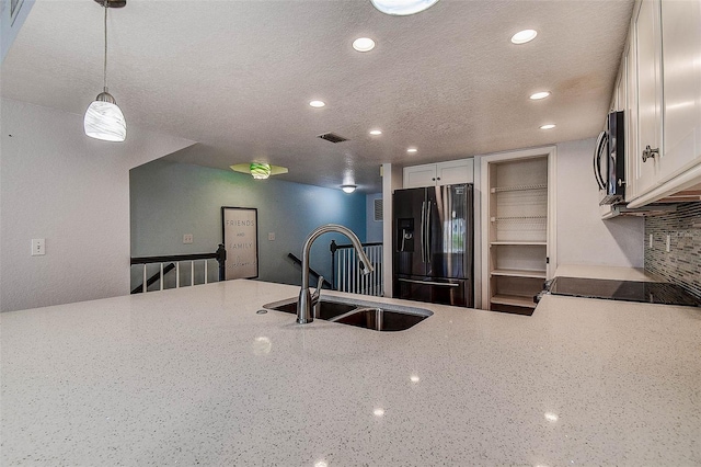 14865 Seminole Trl, Seminole, FL 33776 - kitchen featuring black fridge with ice dispenser, recessed lighting, light stone countertops, stainless steel microwave, and a textured ceiling