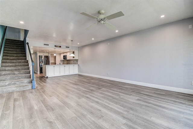 14865 Seminole Trl, Seminole, FL 33776 - unfurnished living room with ceiling fan, light wood-type flooring, stairs, and recessed lighting