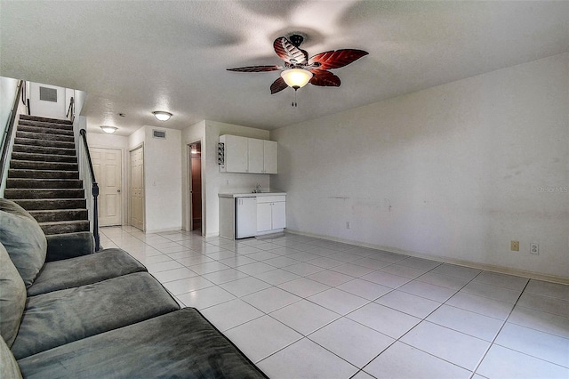 14865 Seminole Trl, Seminole, FL 33776 - unfurnished living room with ceiling fan, light tile patterned floors, stairs, and a textured ceiling