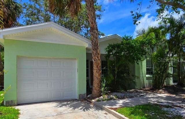 750 Bay Esplanade, Clearwater Beach, FL 33767 - view of front of house with concrete driveway, stucco siding, and an attached garage