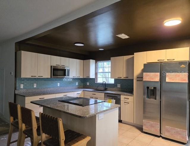 750 Bay Esplanade, Clearwater Beach, FL 33767 - kitchen with stainless steel appliances, a kitchen bar, a center island, tasteful backsplash, and dark stone counters