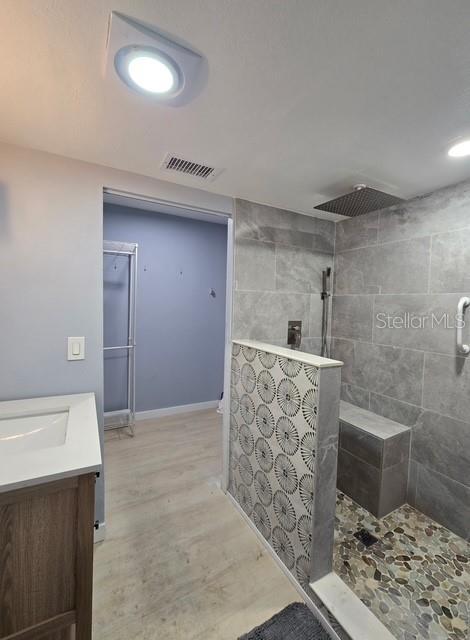 750 Bay Esplanade, Clearwater Beach, FL 33767 - full bathroom with walk in shower, vanity, and wood finished floors