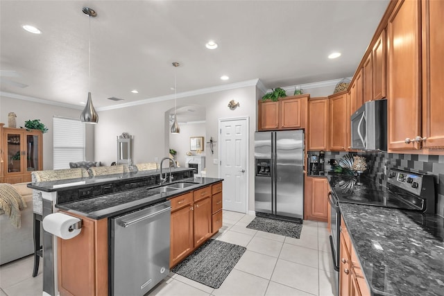 321 Silver Falls Dr, Apollo Beach, FL 33572 - kitchen with appliances with stainless steel finishes, crown molding, a breakfast bar, brown cabinetry, and a kitchen island with sink