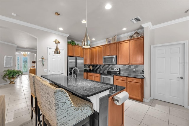 321 Silver Falls Dr, Apollo Beach, FL 33572 - kitchen featuring appliances with stainless steel finishes, crown molding, light tile patterned floors, backsplash, and brown cabinetry