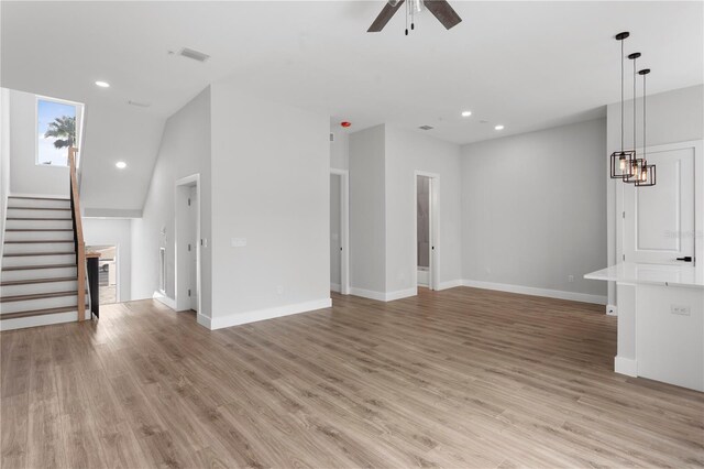11605 1st St E Unit 2, Treasure Island, FL 33706 - unfurnished living room with a ceiling fan, stairs, light wood-style flooring, and recessed lighting