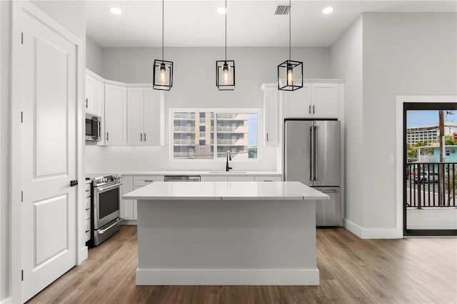11605 1st St E Unit 2, Treasure Island, FL 33706 - kitchen with stainless steel appliances, light wood finished floors, a center island, light countertops, and recessed lighting