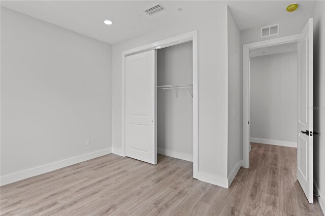 11605 1st St E Unit 2, Treasure Island, FL 33706 - unfurnished bedroom featuring light wood-style flooring, a closet, and recessed lighting