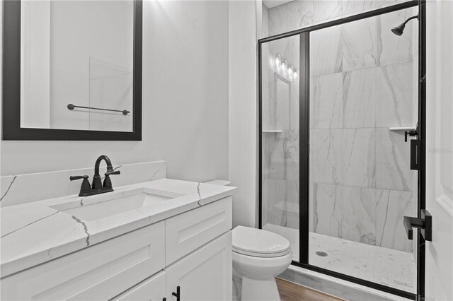 11605 1st St E Unit 2, Treasure Island, FL 33706 - bathroom featuring vanity, a marble finish shower, and wood finished floors