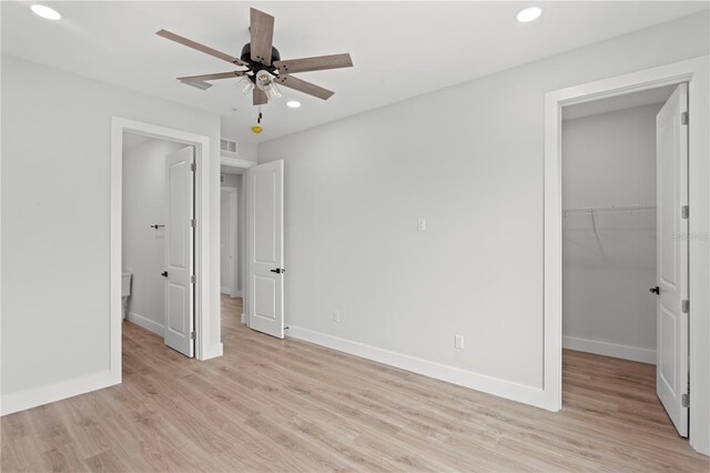 11605 1st St E Unit 2, Treasure Island, FL 33706 - unfurnished bedroom featuring a spacious closet, recessed lighting, light wood finished floors, and a ceiling fan