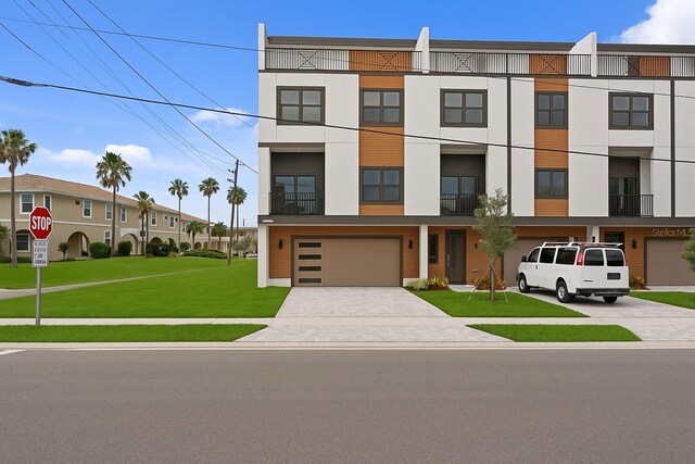 11605 1st St E Unit 2, Treasure Island, FL 33706 - view of property featuring driveway, an attached garage, and a front yard