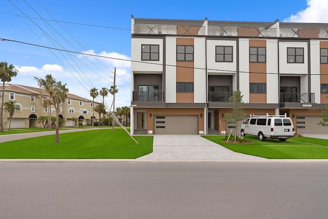 11605 1st St E Unit 2, Treasure Island, FL 33706 - view of property with an attached garage, a front lawn, and driveway