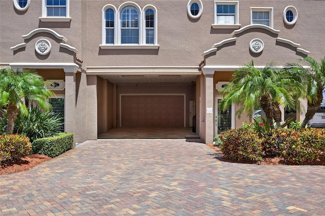 2756 Reserve Ct, Dunedin, FL 34698 - mediterranean / spanish home with a garage, stucco siding, and decorative driveway