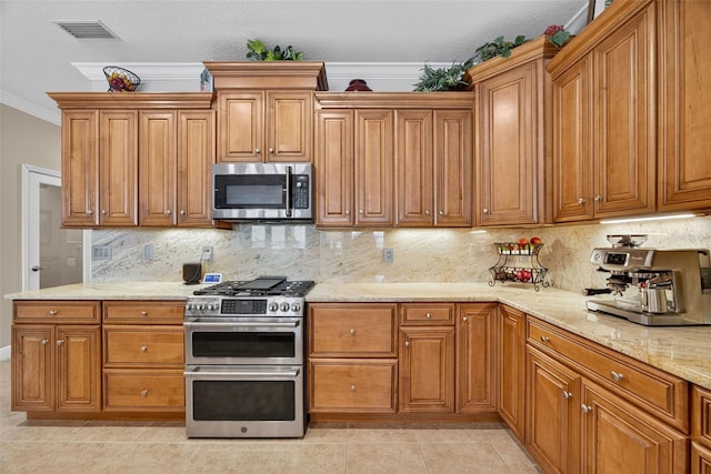 2756 Reserve Ct, Dunedin, FL 34698 - kitchen with stainless steel appliances, crown molding, and brown cabinetry