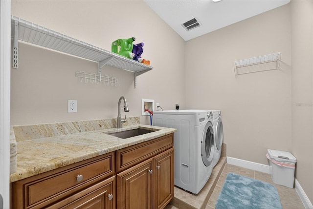2756 Reserve Ct, Dunedin, FL 34698 - washroom with washer and dryer, cabinet space, and light tile patterned flooring