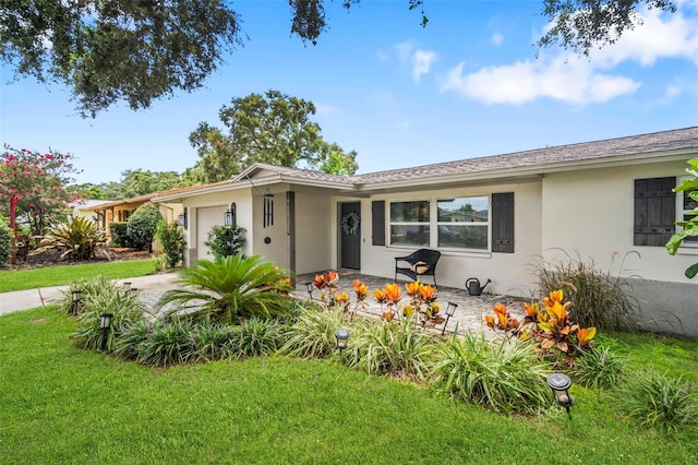 980 8th Ave NE, Largo, FL 33770 - view of front of home featuring stucco siding, a garage, and a front lawn